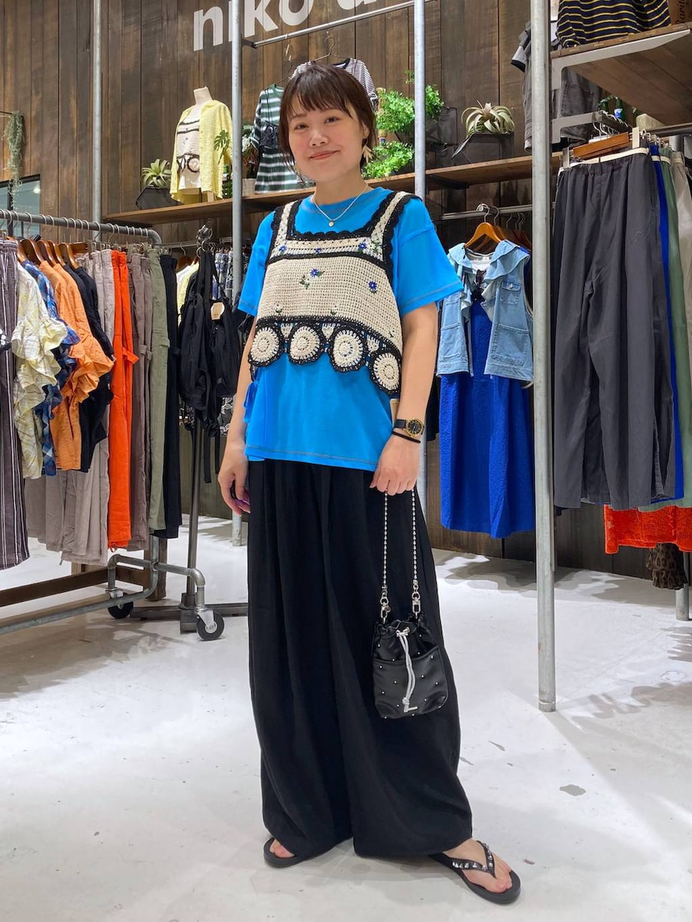 ブラック系のショルダーバッグ、ホワイト系のキャミソール、ブラック系のサンダルを着用したレディースの夏コーディネートの2枚目の写真