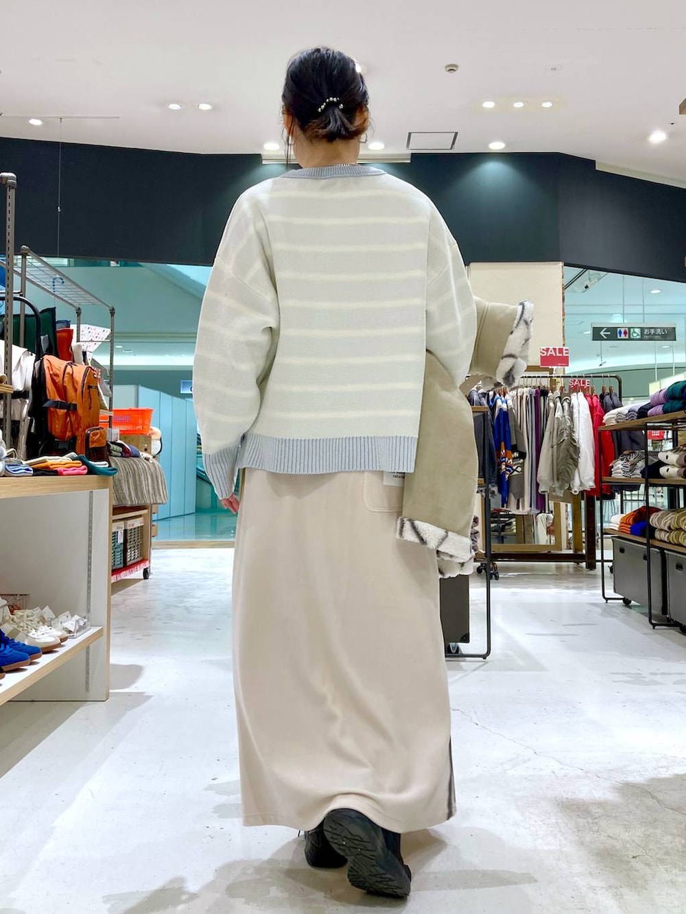 ベージュ系のニット/セーター、グリーン系のショルダーバッグ、ベージュ系のムートンコートを着用したレディースの冬コーディネートの4枚目の写真