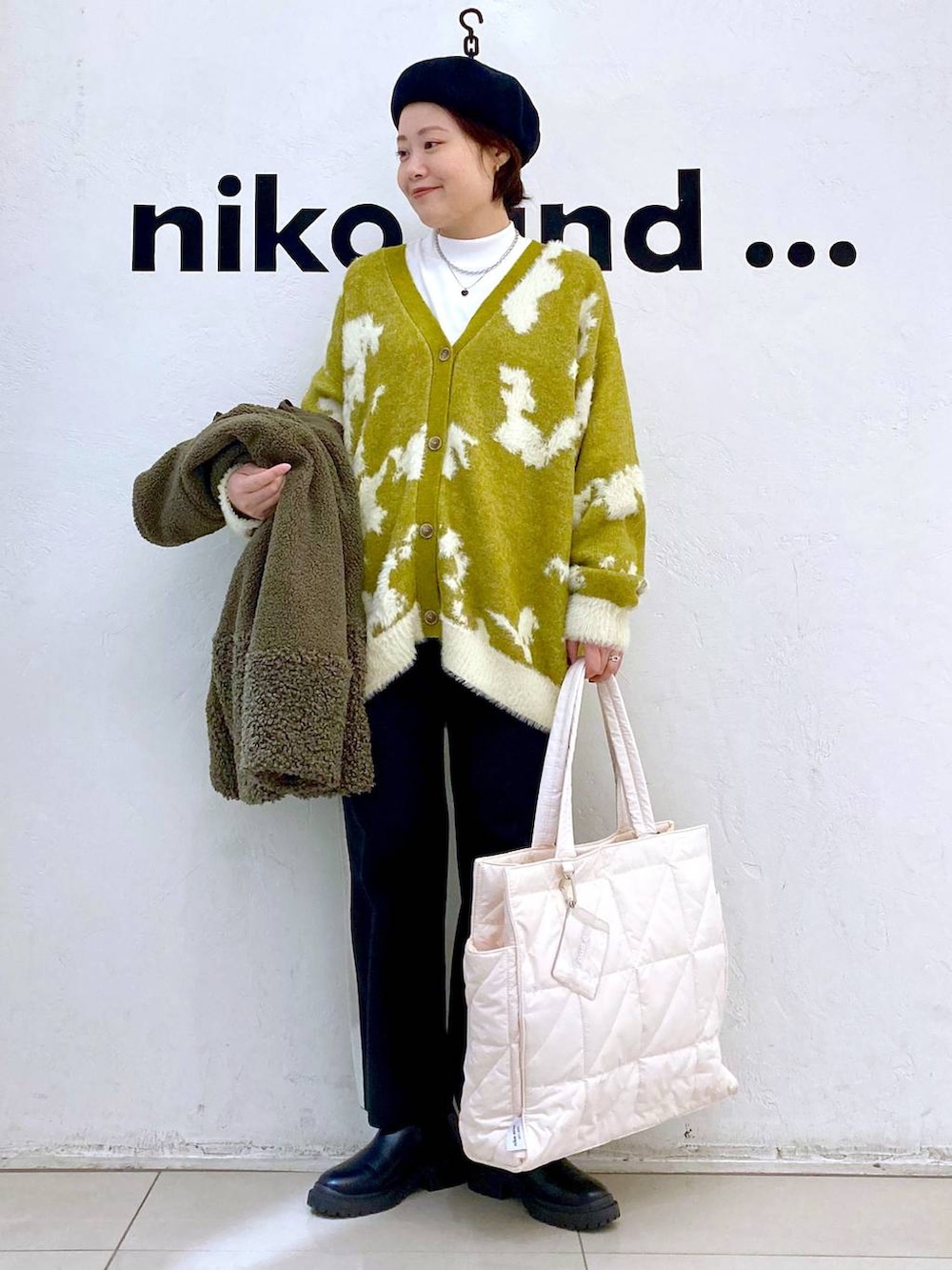 グリーン系のその他アウター、ホワイト系のその他パンツ、ブラック系のブーツを着用したレディースの冬コーディネートの2枚目の写真
