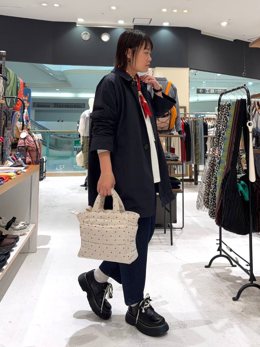 ブラック系のその他シューズ、ホワイト系のトートバッグ、ブルー系のステンカラーコートを着用したレディースの春コーディネートの4枚目の写真