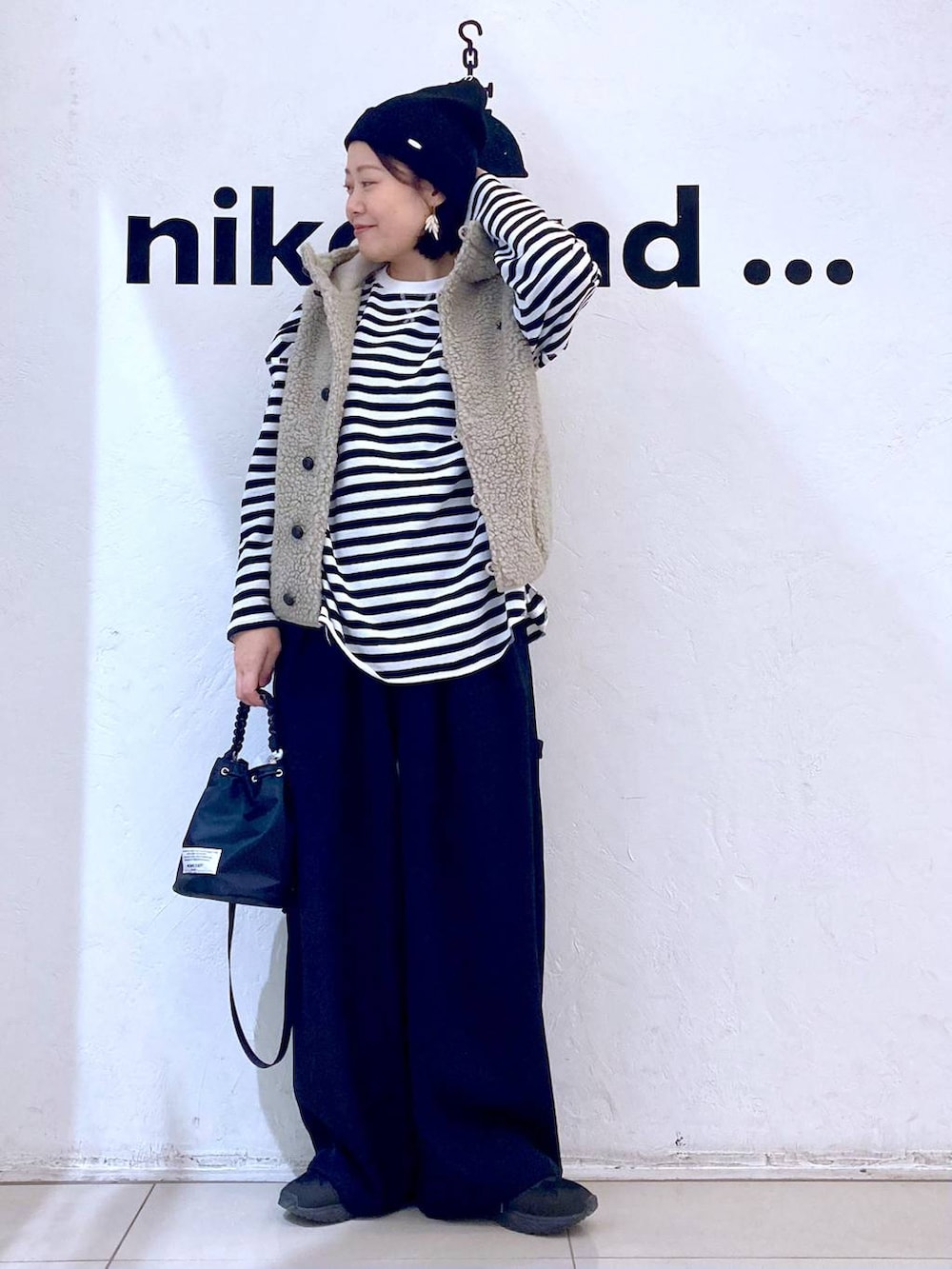 ベージュ系のベスト、ブラック系のその他パンツ、ブラック系のショルダーバッグを着用したレディースの冬コーディネートの2枚目の写真