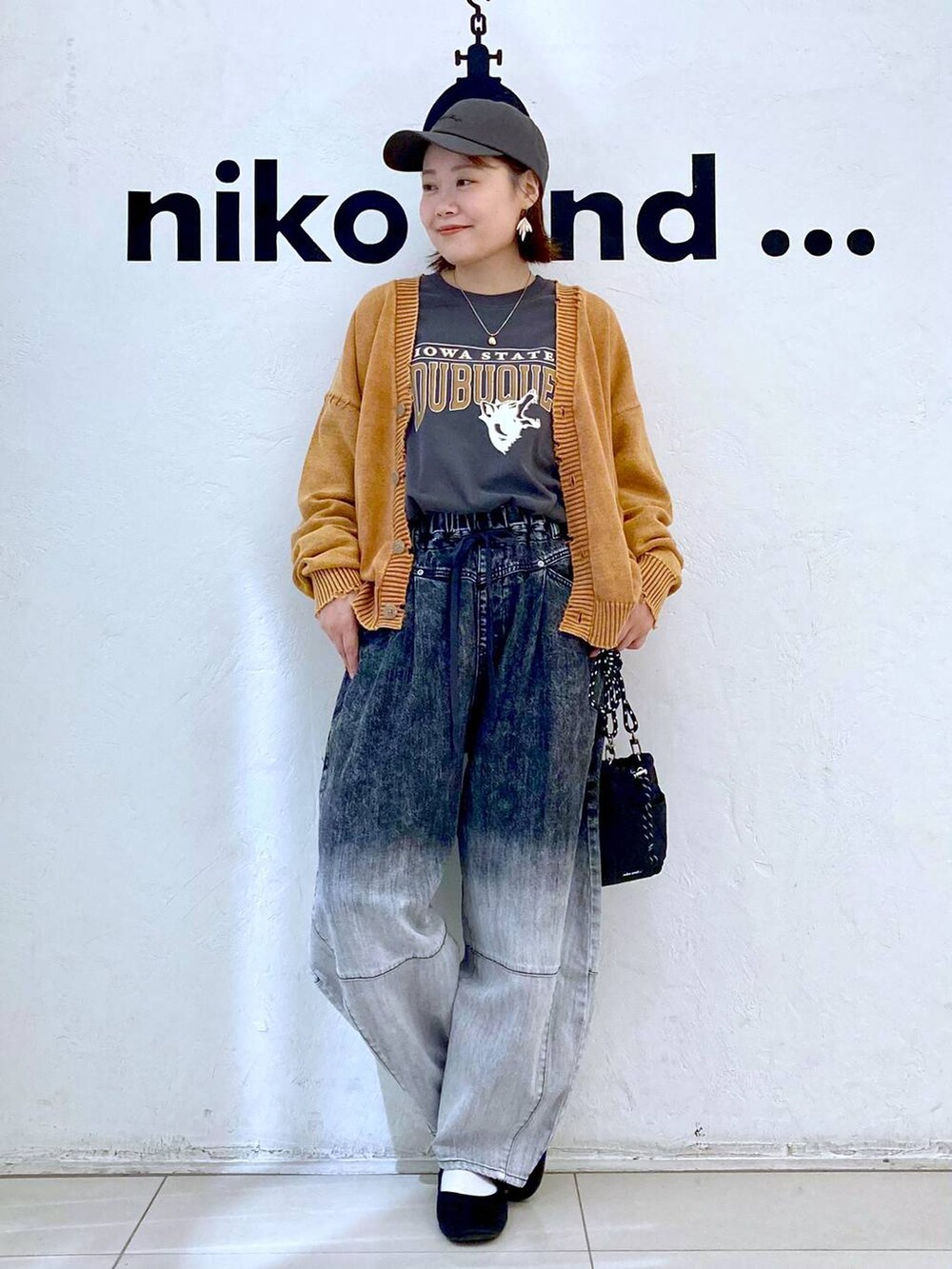 ブラック系のショルダーバッグ、グレー系のTシャツ/カットソー、ブラック系のデニムパンツを着用したレディースの秋コーディネートの2枚目の写真