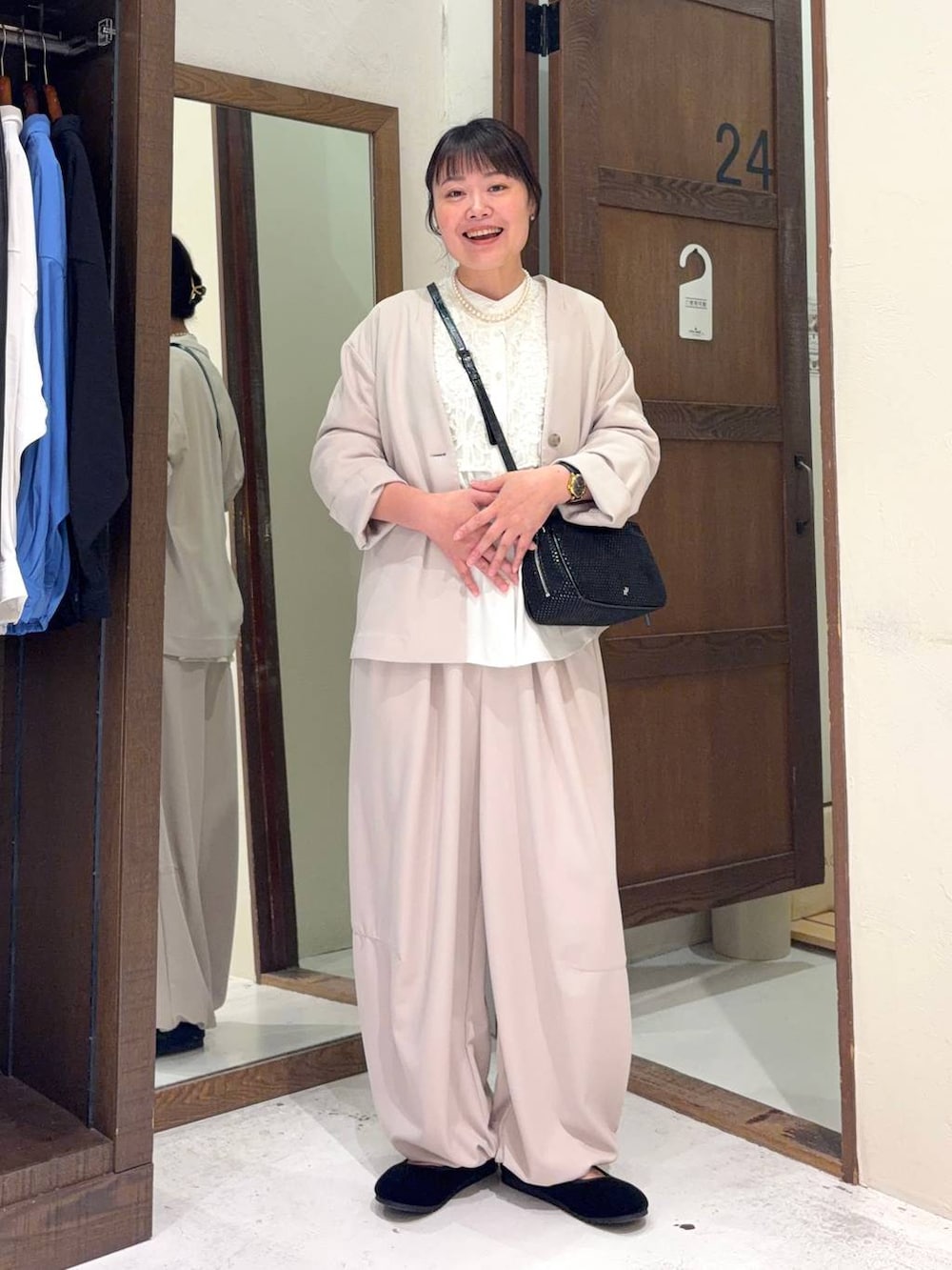 ブラック系のパンプス、ホワイト系のシャツ/ブラウス、その他のショルダーバッグを着用したレディースの冬コーディネートの4枚目の写真