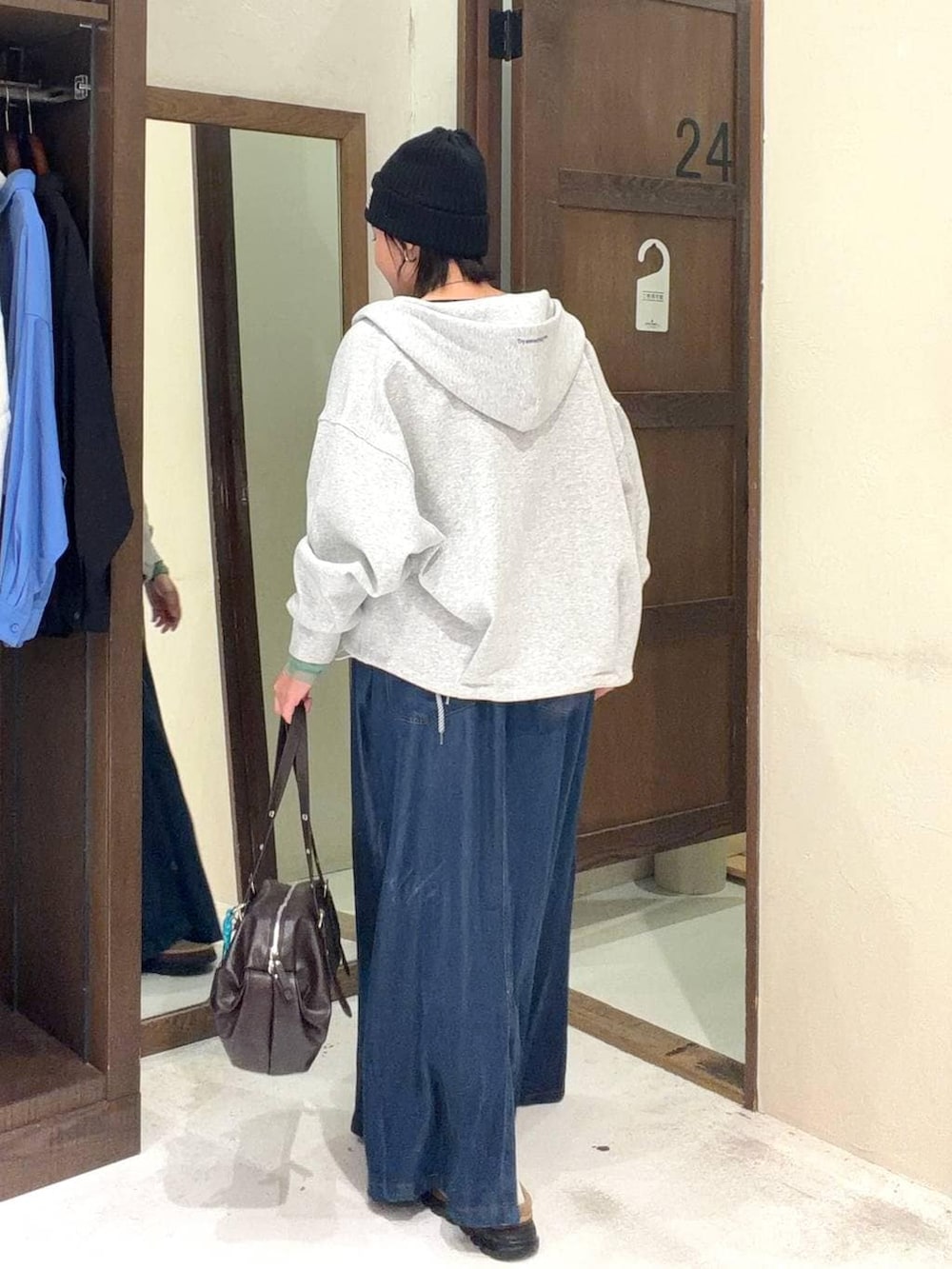 ブラウン系のボストンバッグ、ブラック系のTシャツ/カットソー、グレー系のパーカーを着用したレディースの春コーディネートの4枚目の写真