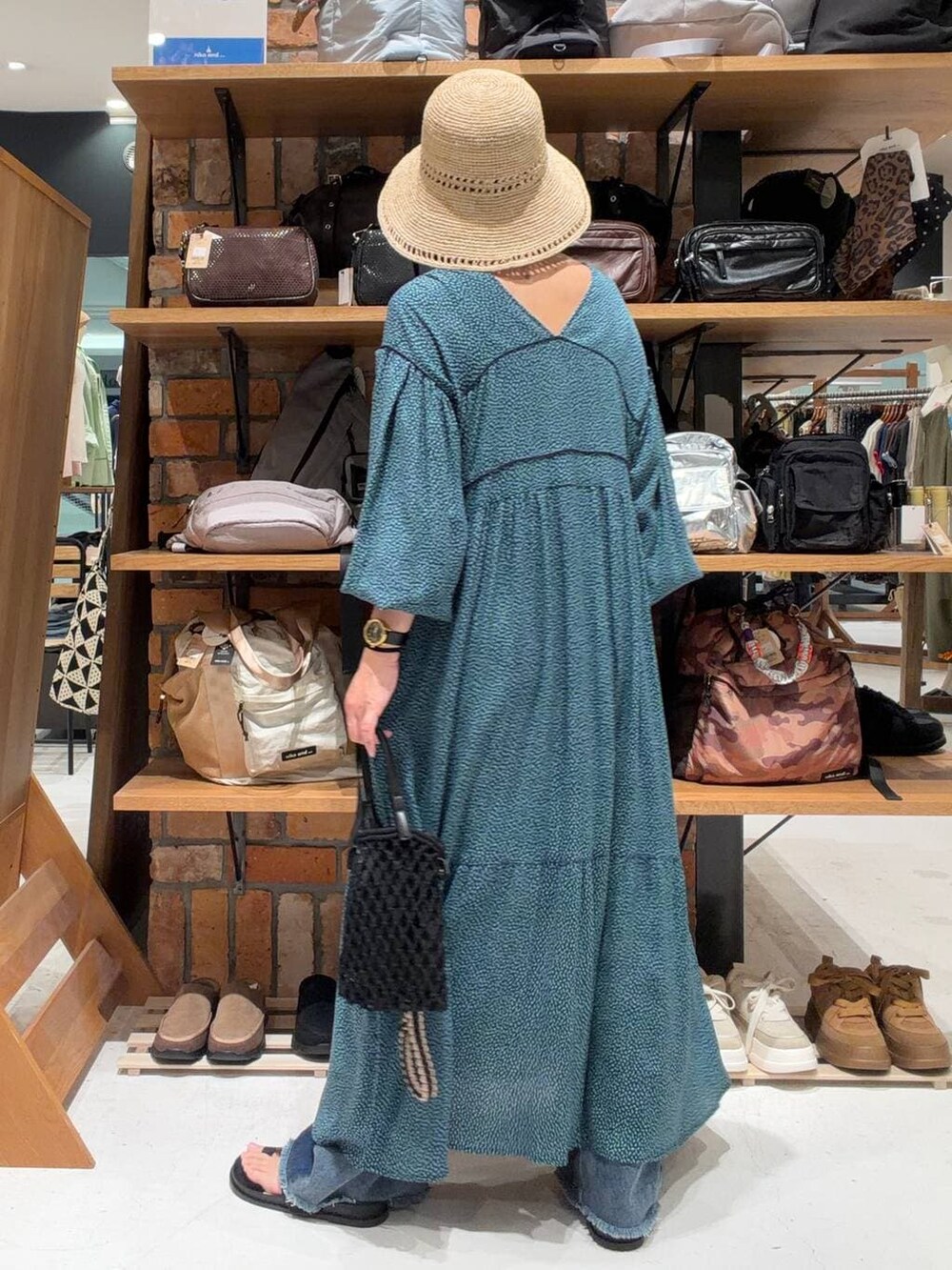 ブルー系のデニムパンツ、ブルー系のワンピース、ブラック系のトートバッグを着用したレディースの春コーディネートの5枚目の写真