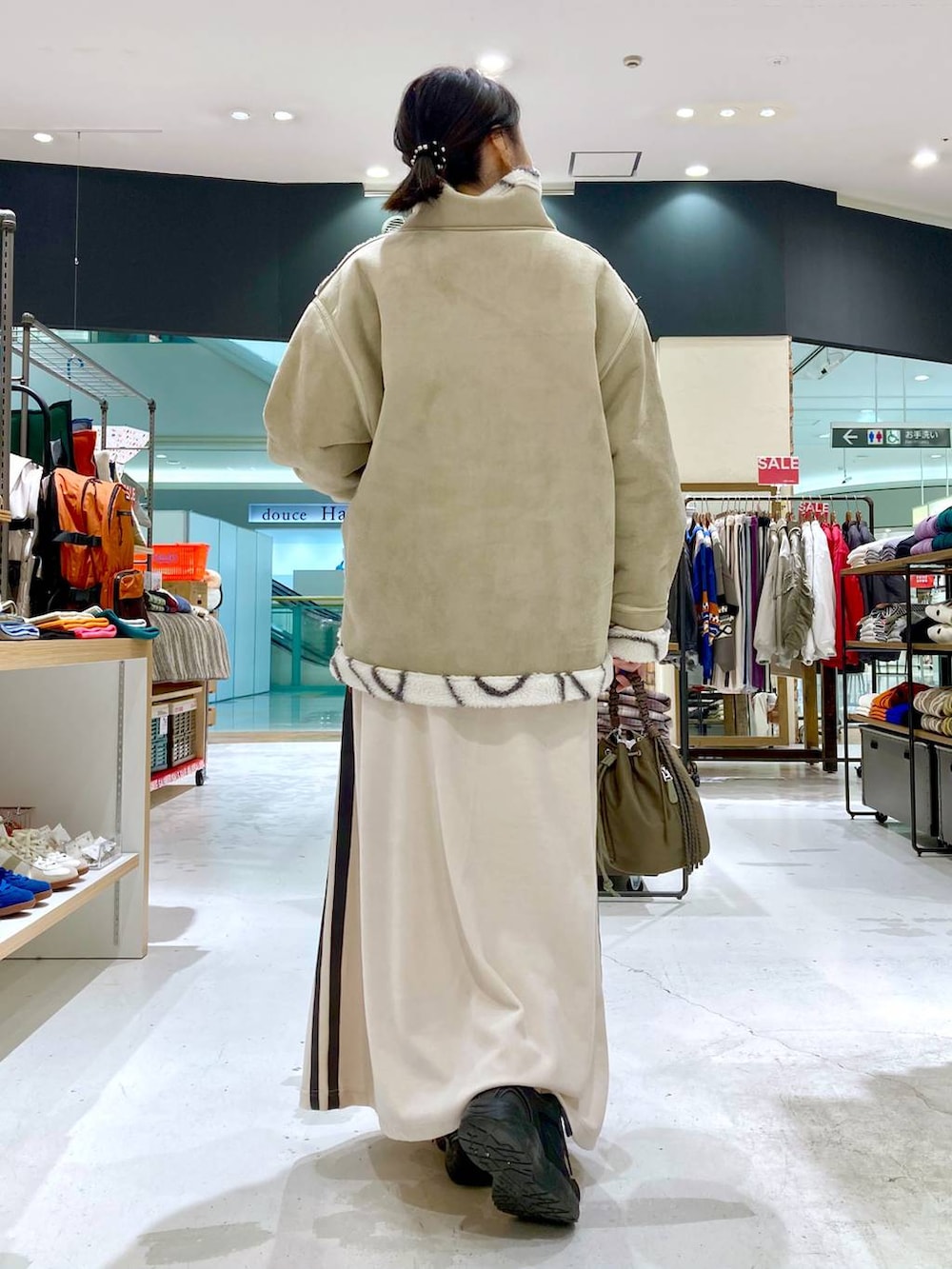 ベージュ系のニット/セーター、グリーン系のショルダーバッグ、ベージュ系のムートンコートを着用したレディースの冬コーディネートの5枚目の写真