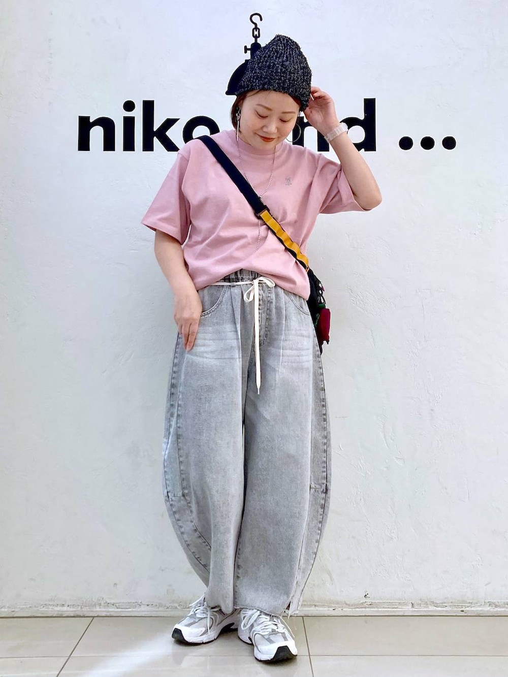 ブラック系のショルダーバッグ、グレー系のデニムパンツ、ピンク系のTシャツ/カットソーを着用したレディースの夏コーディネートの2枚目の写真