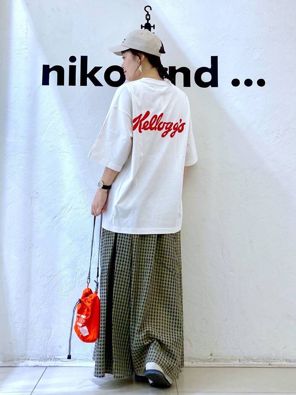 ホワイト系のスニーカー、オレンジ系のショルダーバッグ、ホワイト系のTシャツ/カットソーを着用したレディースの春コーディネートの4枚目の写真