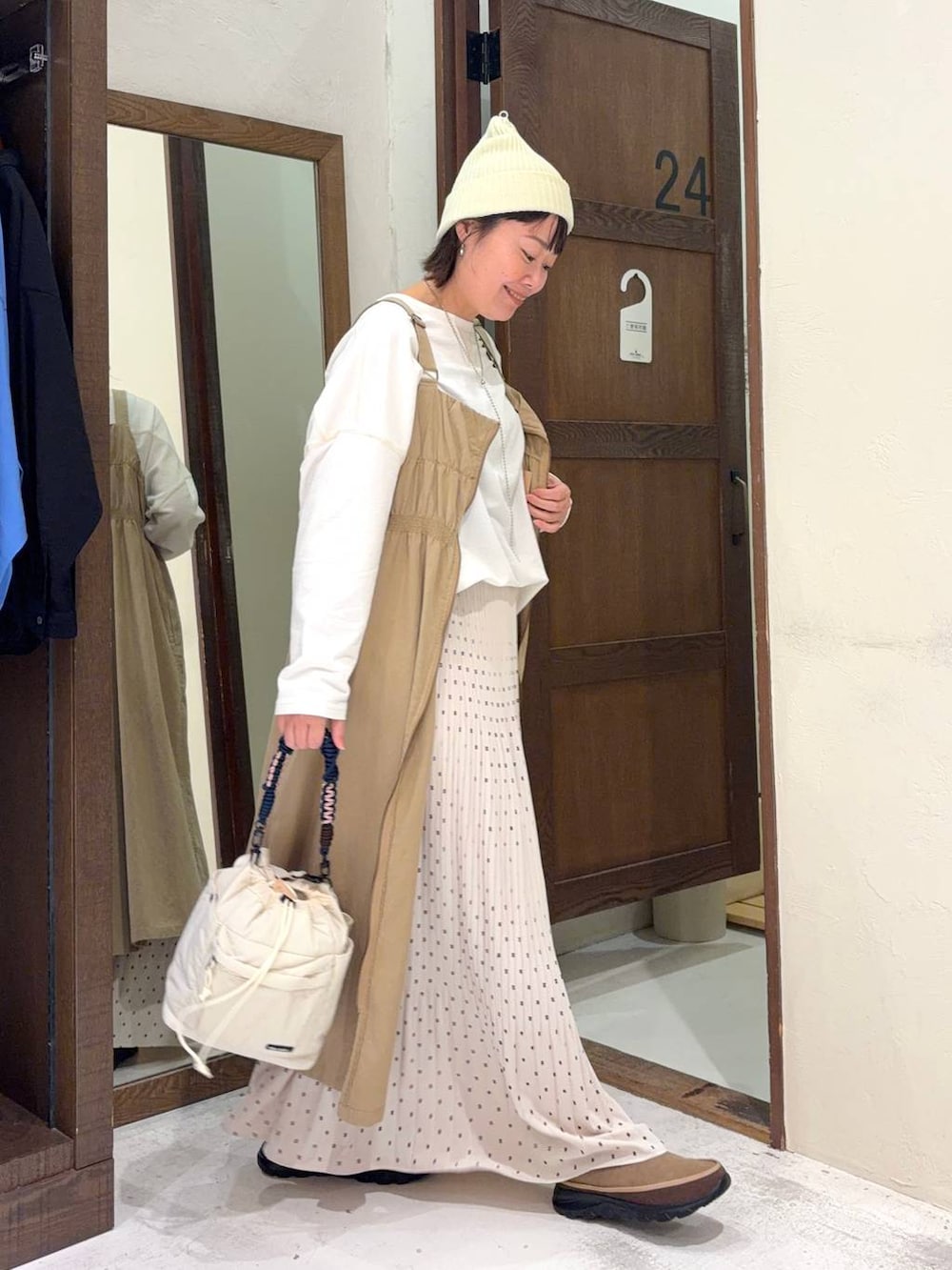 ベージュ系のジャンパースカート、ベージュ系のその他シューズ、ホワイト系のTシャツ/カットソーを着用したレディースの冬コーディネートの4枚目の写真