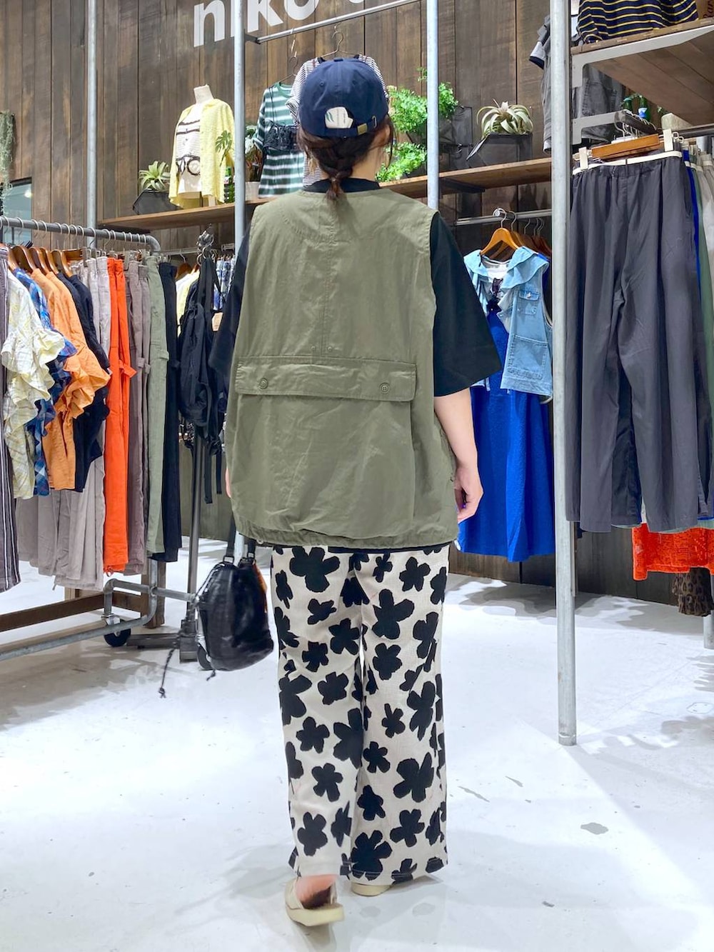 ホワイト系のその他パンツ、ブラック系のTシャツ/カットソー、グリーン系のベストを着用したレディースの夏コーディネートの4枚目の写真
