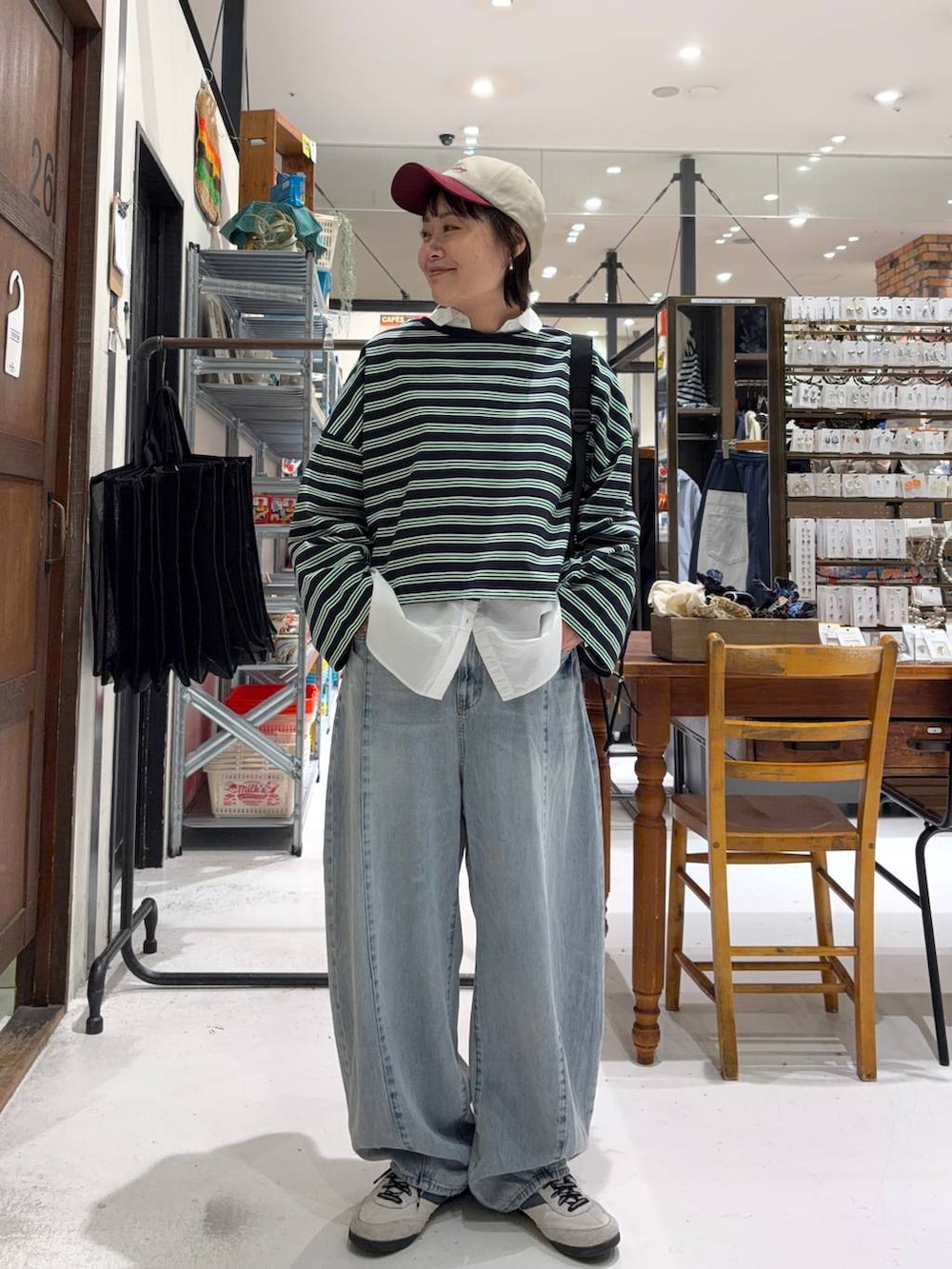 ブラック系のバックパック/リュック、ホワイト系のシャツ/ブラウス、ブルー系のデニムパンツを着用したレディースの冬コーディネートの2枚目の写真