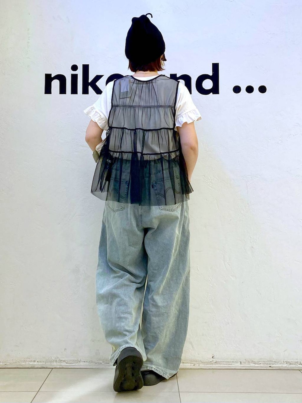 ブラック系のサンダル、ホワイト系のTシャツ/カットソー、ブラック系のベストを着用したレディースの夏コーディネートの4枚目の写真