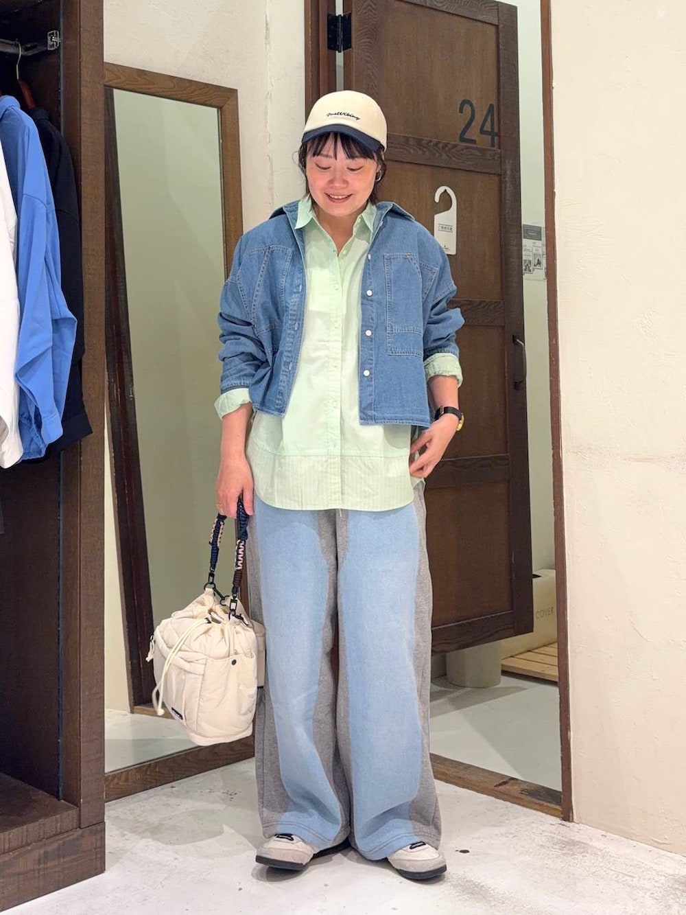 グレー系のデニムパンツ、グリーン系のシャツ/ブラウス、ベージュ系のショルダーバッグを着用したレディースの春コーディネートの5枚目の写真