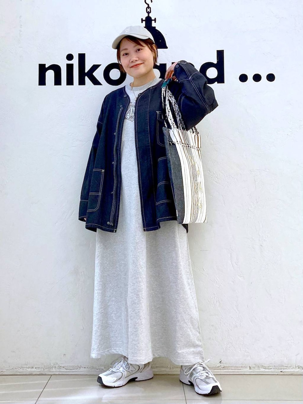 ベージュ系のワンピース、ブラック系のトートバッグ、その他のブルゾンを着用したレディースの春コーディネートの2枚目の写真