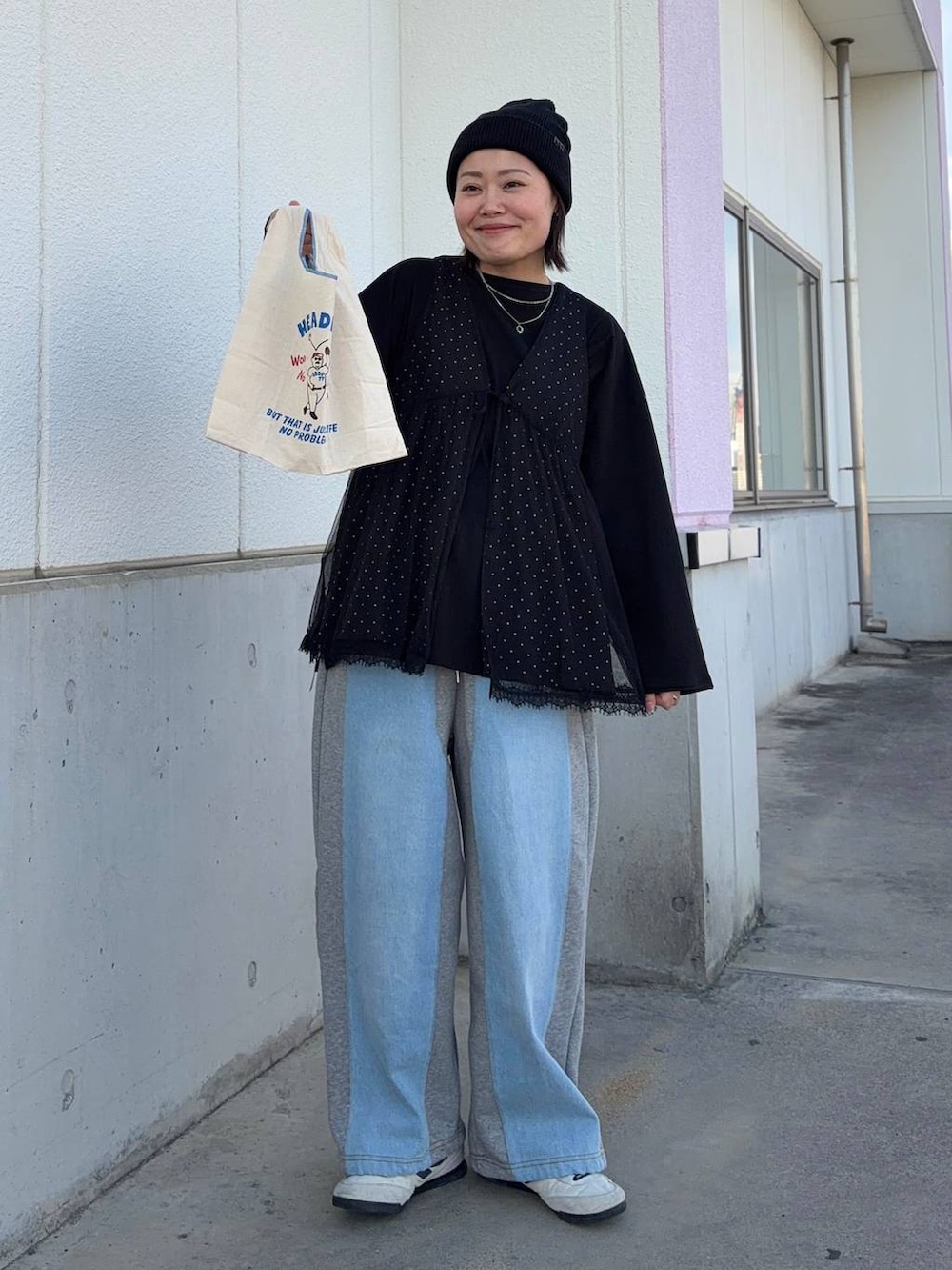 グレー系のデニムパンツ、ブラック系のTシャツ/カットソー、ブラック系のベストを着用したレディースの春コーディネートの2枚目の写真