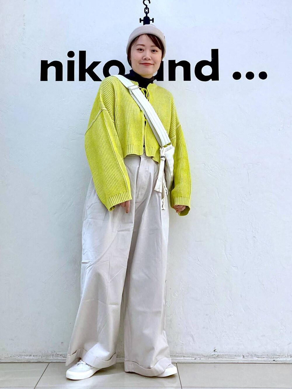 ベージュ系のその他パンツ、イエロー系のニット/セーター、ホワイト系のスニーカーを着用したレディースの冬コーディネートの2枚目の写真