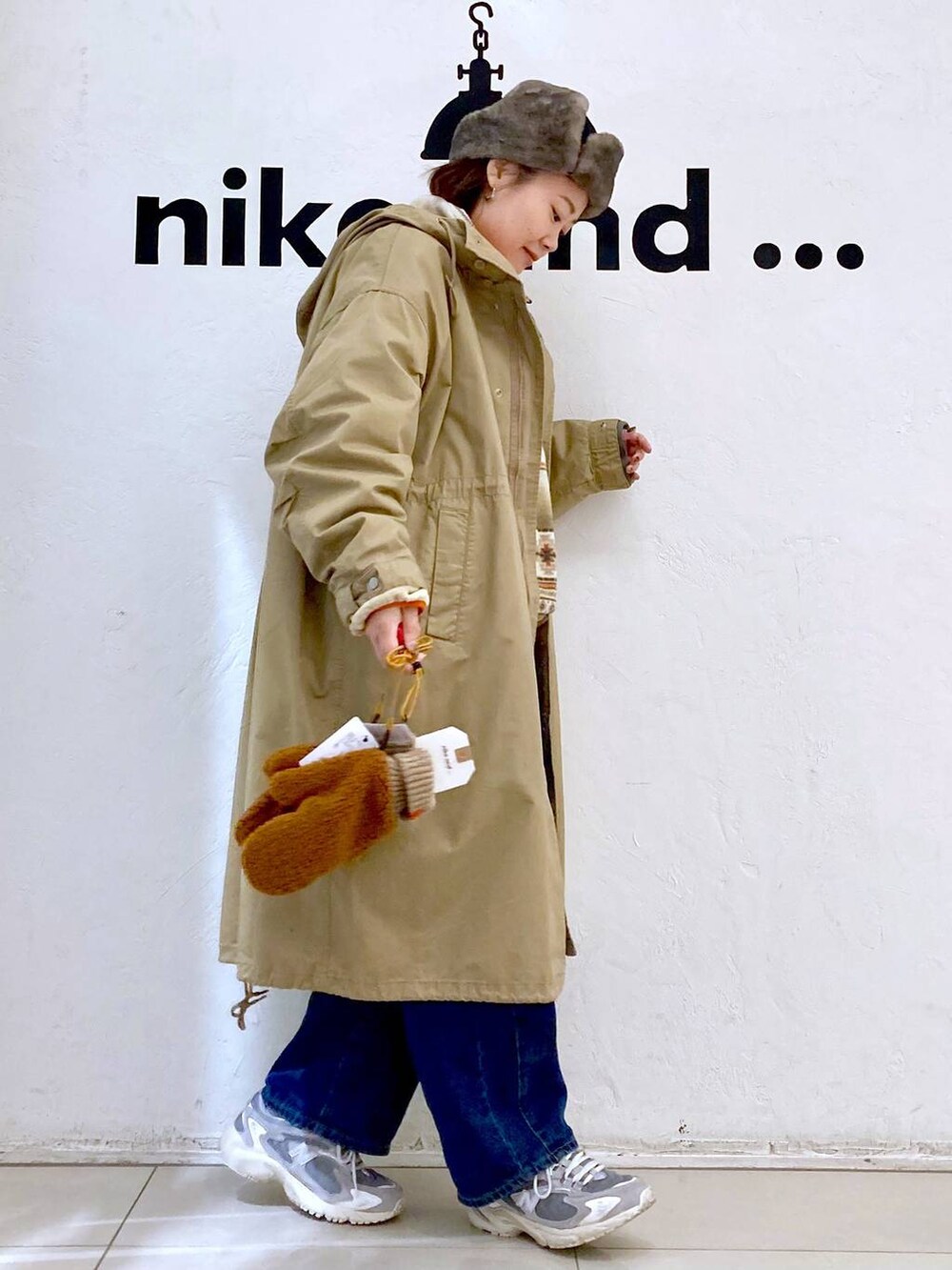 イエロー系のモッズコート、ブルー系のデニムパンツ、ホワイト系のTシャツ/カットソーを着用したレディースの秋コーディネートの5枚目の写真