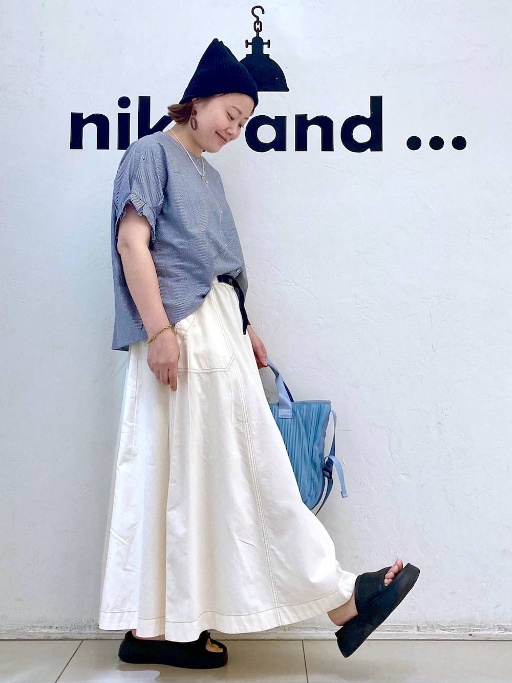 ブラック系のサンダル、ブルー系のTシャツ/カットソー、ブルー系のトートバッグを着用したレディースの夏コーディネートの3枚目の写真