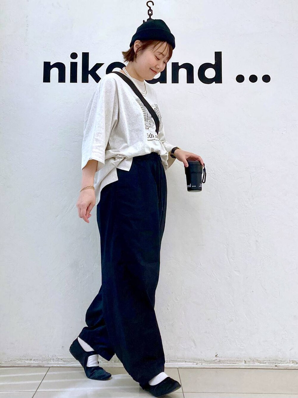 ベージュ系のTシャツ/カットソー、ブラック系のショルダーバッグ、ブラック系のその他パンツを着用したレディースの春コーディネートの3枚目の写真