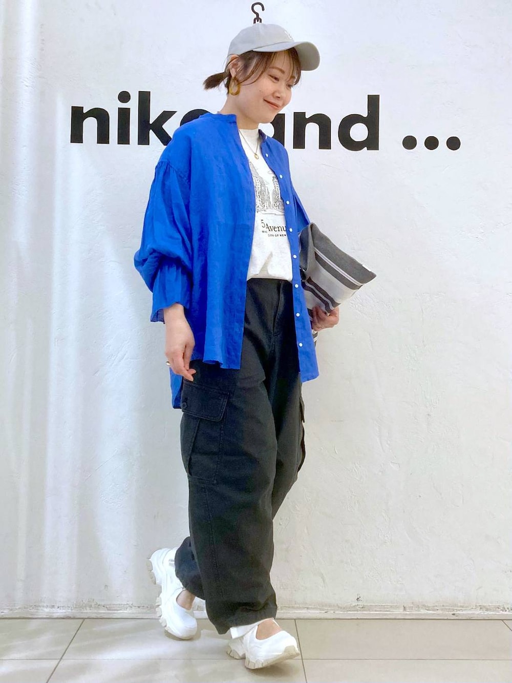 ベージュ系のTシャツ/カットソー、ブルー系のシャツ/ブラウス、グレー系のカーゴパンツを着用したレディースの春コーディネートの2枚目の写真