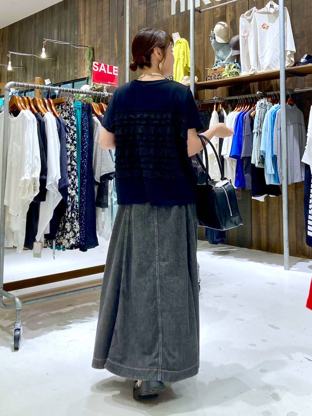 グレー系のスカート、ブラック系のボストンバッグ、ブラック系のTシャツ/カットソーを着用したレディースの夏コーディネートの4枚目の写真