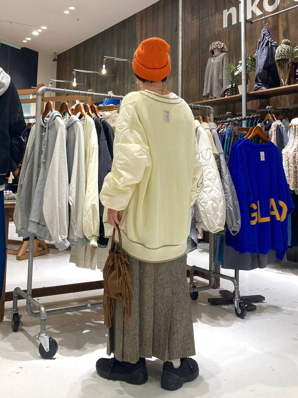 ブラウン系のスカート、ブラウン系のショルダーバッグ、ホワイト系のTシャツ/カットソーを着用したレディースの秋コーディネートの4枚目の写真
