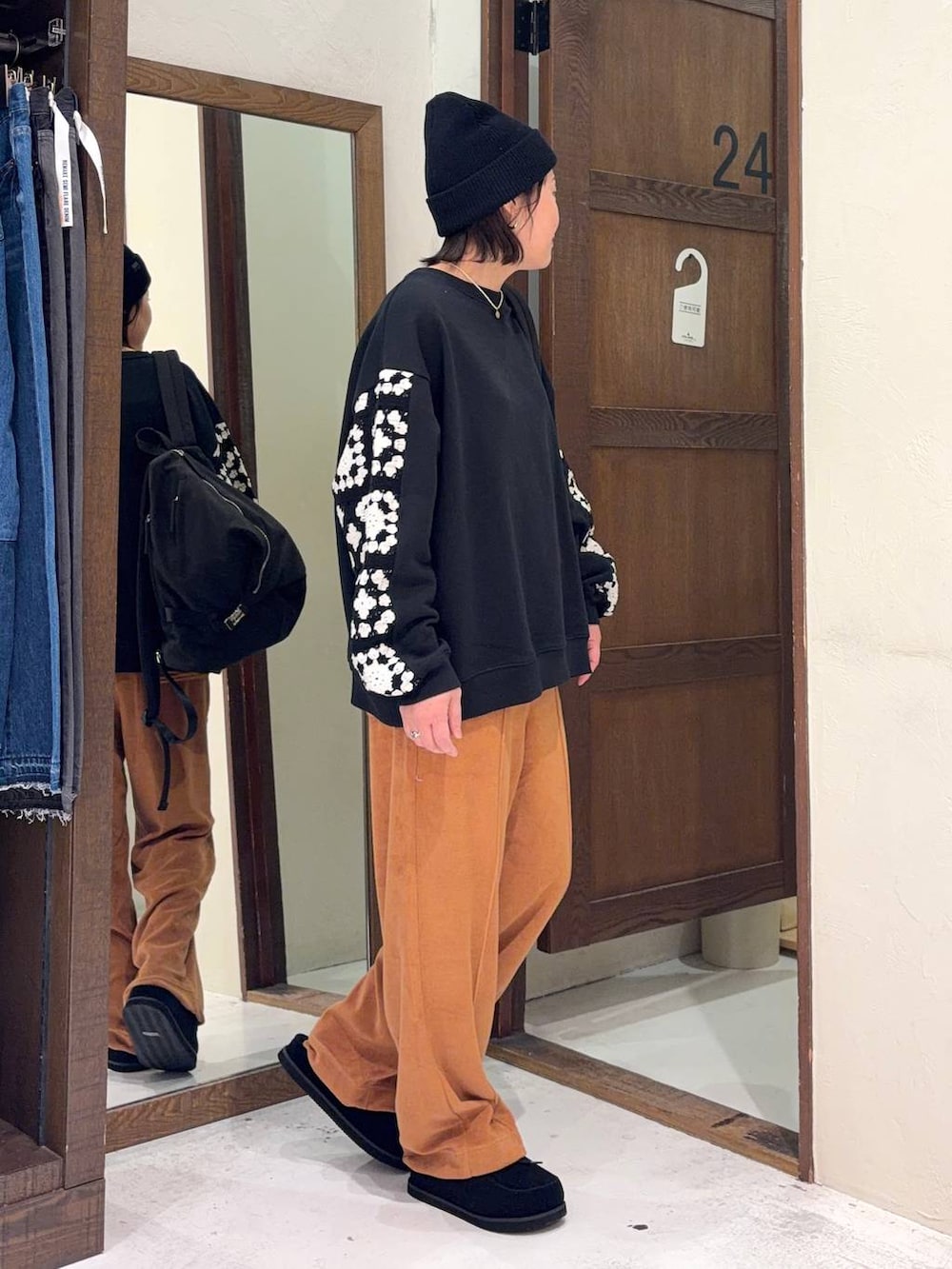 ブラック系のスウェット、オレンジ系のその他パンツ、ブラック系のモカシン/デッキシューズを着用したレディースの春コーディネートの3枚目の写真