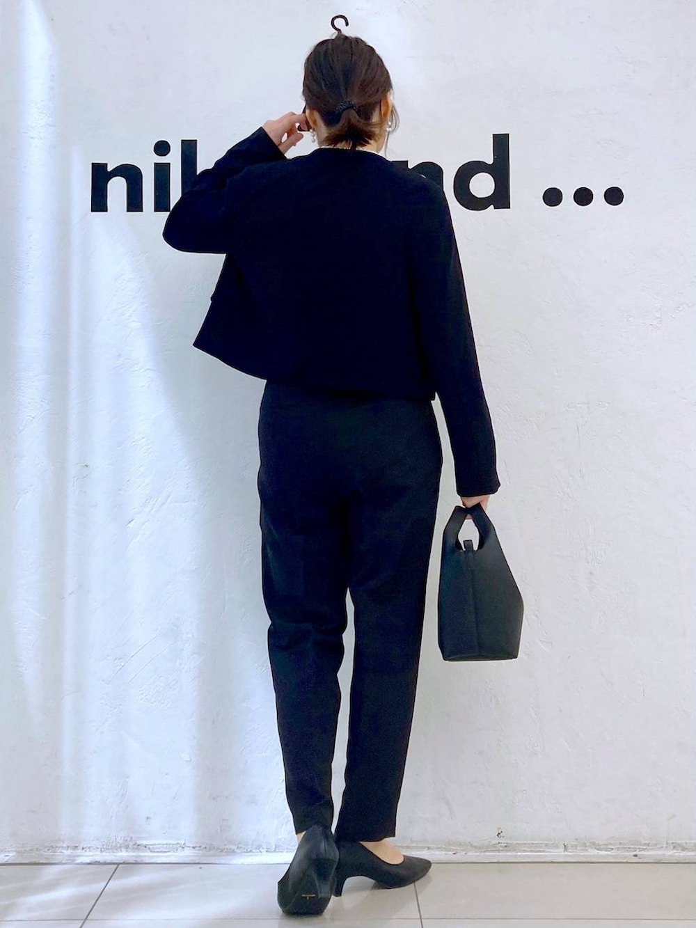 ブラック系のスーツパンツ、ホワイト系のシャツ/ブラウス、ブラック系のノーカラージャケットを着用したレディースの冬コーディネートの4枚目の写真