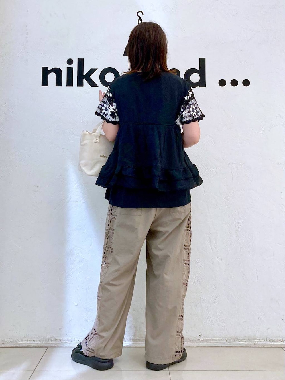 ホワイト系のトートバッグ、ブラウン系のその他パンツ、ブラック系のベストを着用したレディースの夏コーディネートの4枚目の写真
