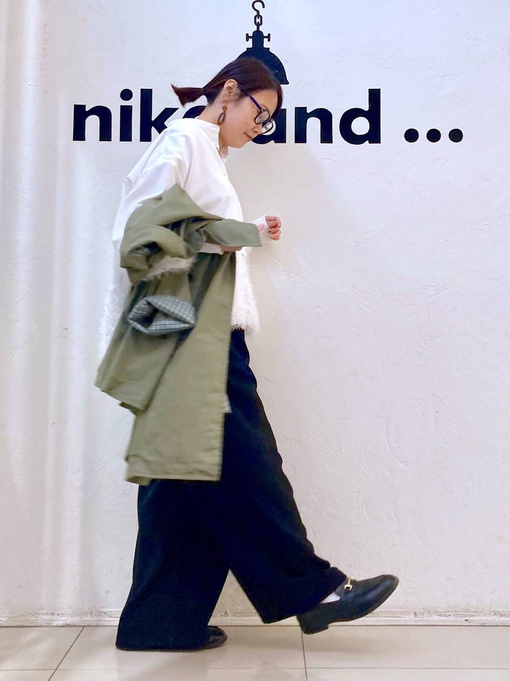 ブラック系のその他パンツ、グリーン系のトレンチコート、ホワイト系のシャツ/ブラウスを着用したレディースの冬コーディネートの4枚目の写真