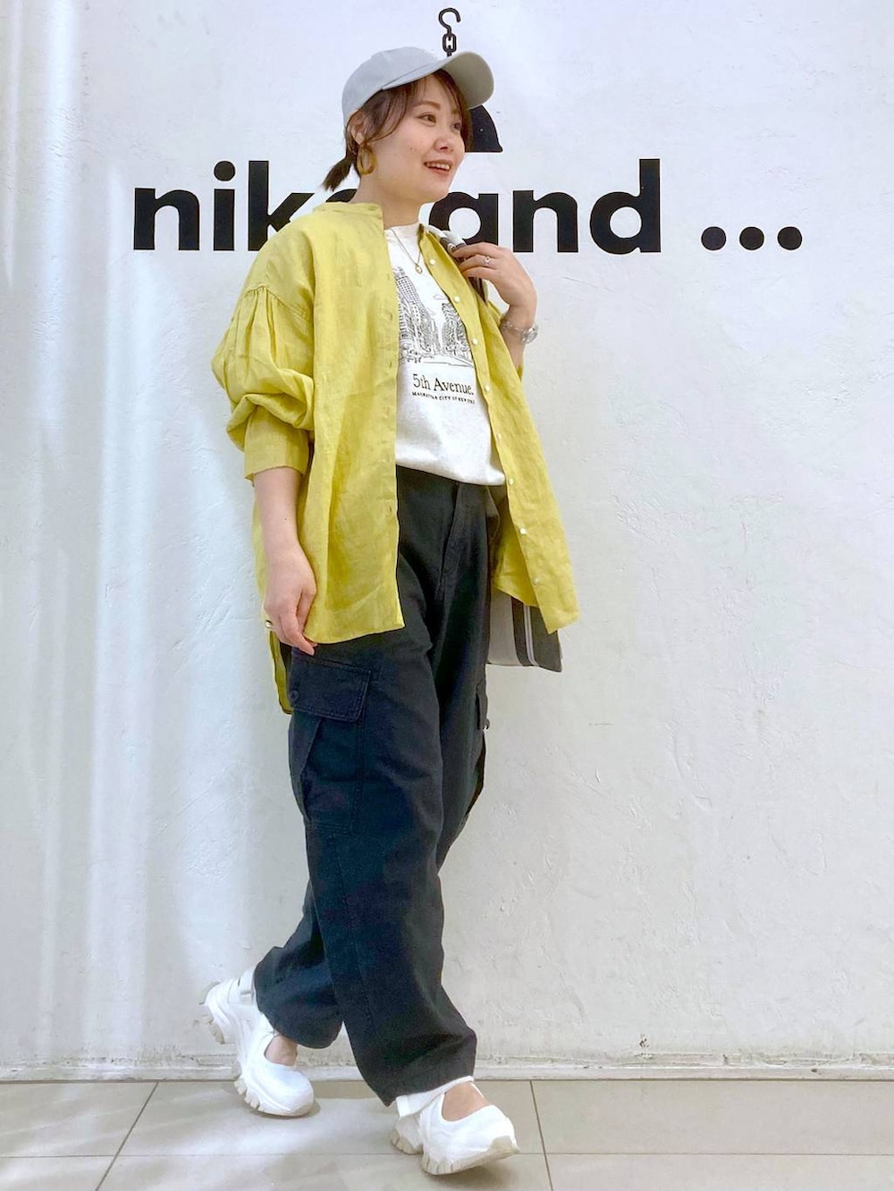 ベージュ系のTシャツ/カットソー、イエロー系のシャツ/ブラウス、グレー系のカーゴパンツを着用したレディースの春コーディネートの3枚目の写真