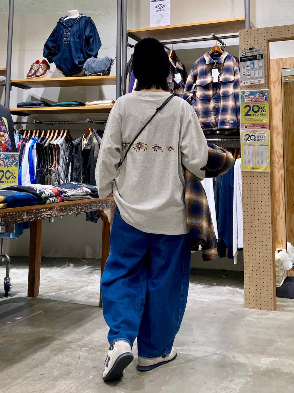 ブルー系のデニムパンツ、ブラウン系のブルゾン、ベージュ系のショルダーバッグを着用したレディースの秋コーディネートの3枚目の写真