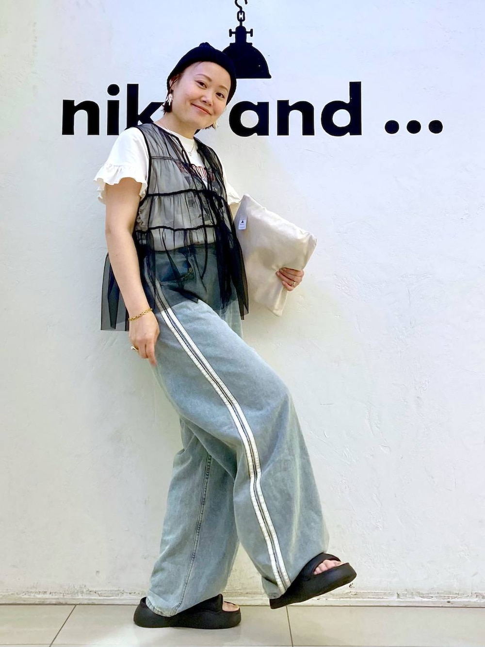 ブラック系のサンダル、ホワイト系のTシャツ/カットソー、ブラック系のベストを着用したレディースの夏コーディネートの3枚目の写真