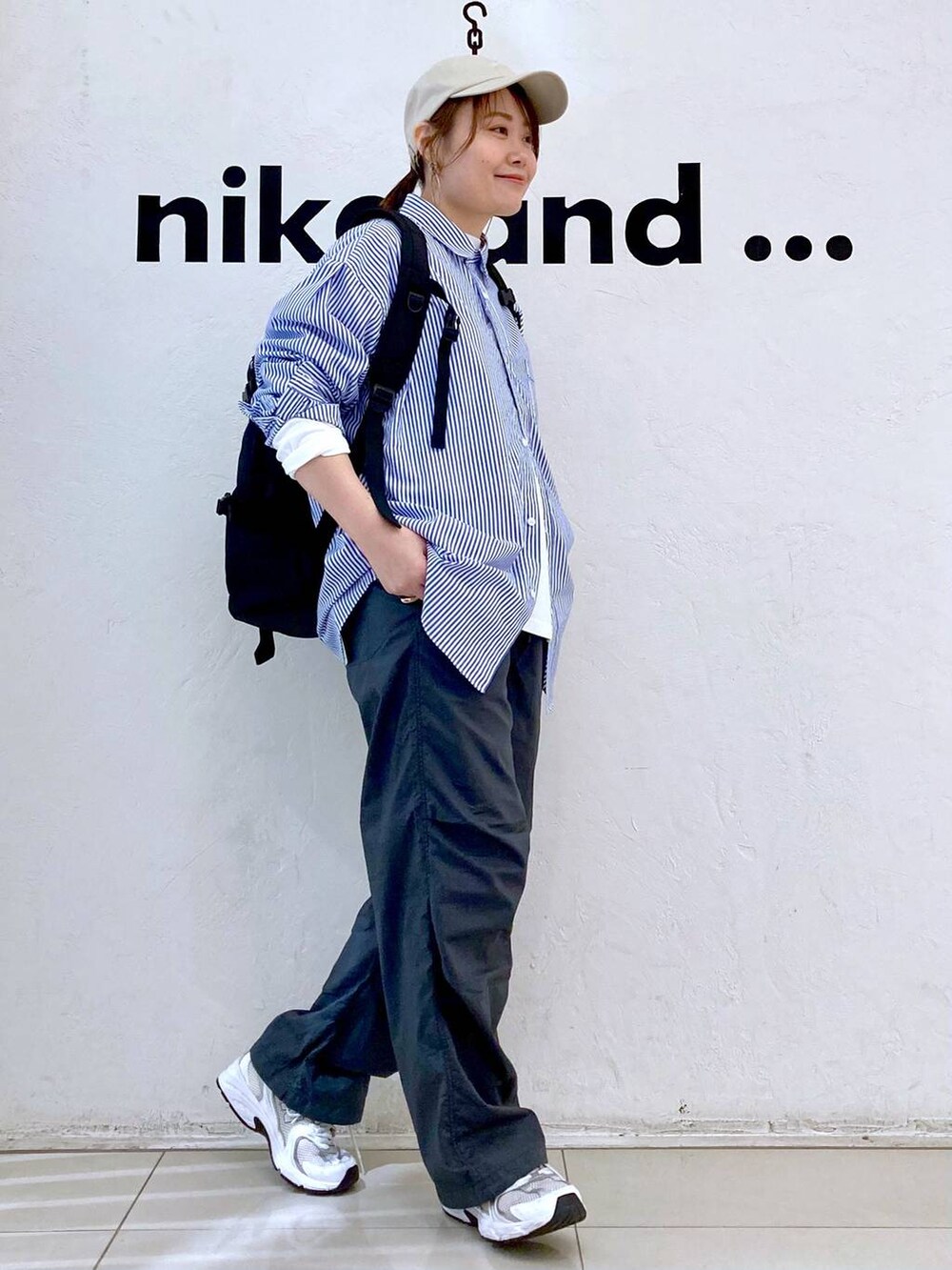 ホワイト系のTシャツ/カットソー、ブラック系のバックパック/リュック、グレー系のその他パンツを着用したレディースの春コーディネートの3枚目の写真