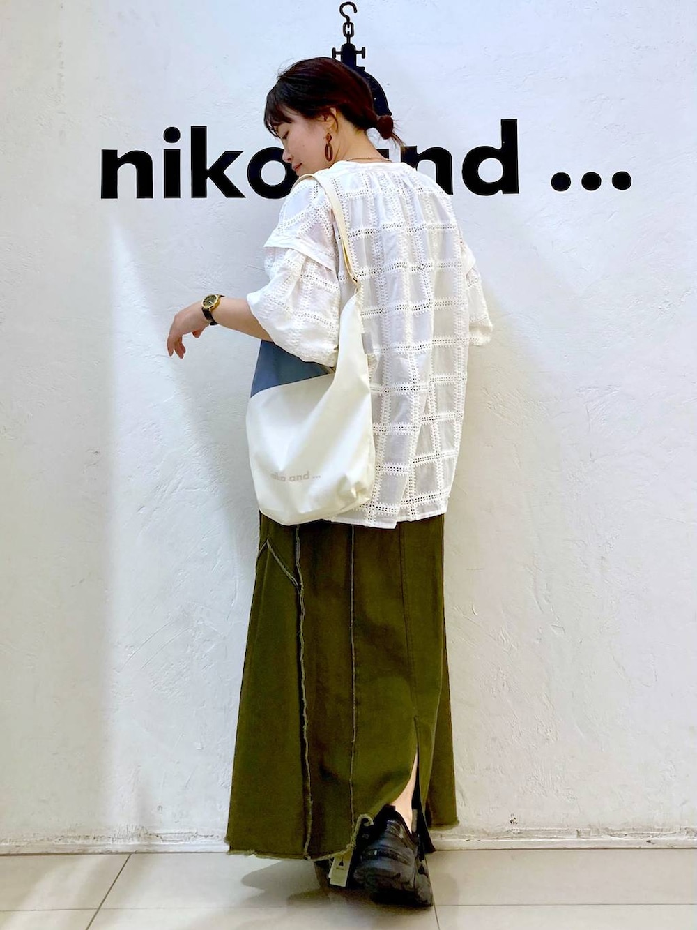 グレー系のタンクトップ、ベージュ系のトートバッグ、ブラック系のスニーカーを着用したレディースの春コーディネートの5枚目の写真