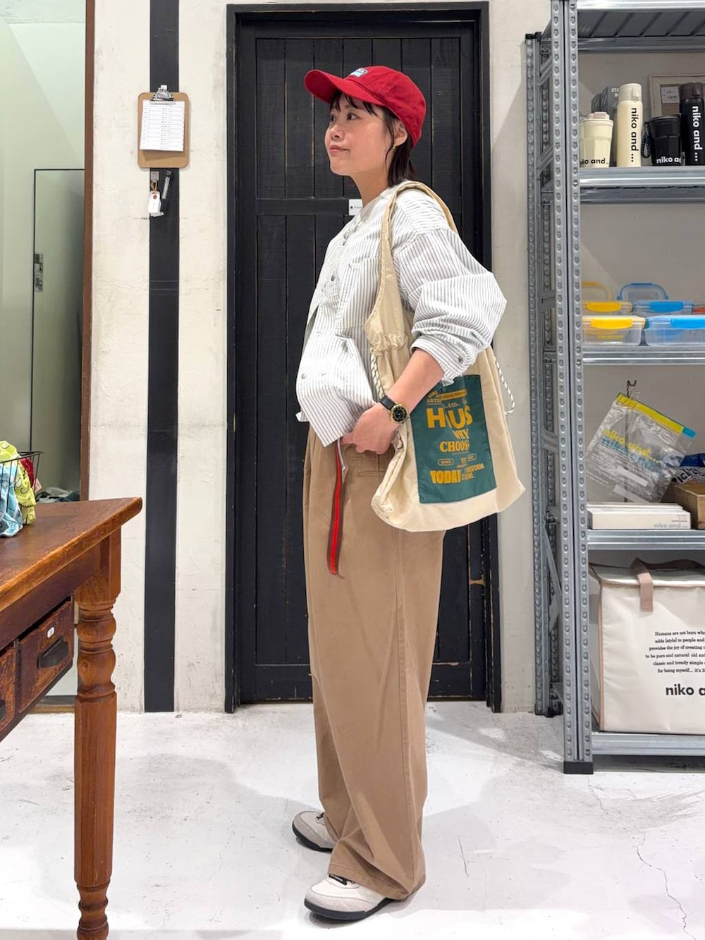 ホワイト系のトートバッグ、ベージュ系のカバーオール、ホワイト系のTシャツ/カットソーを着用したレディースの春コーディネートの3枚目の写真