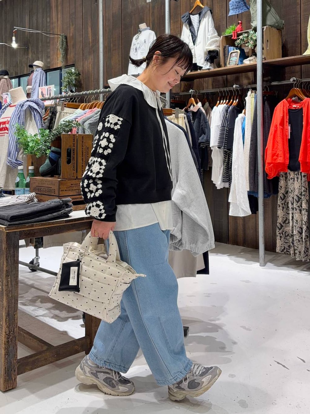 ブラック系のスウェット、ホワイト系のトートバッグ、ブルー系のその他パンツを着用したレディースの春コーディネートの4枚目の写真