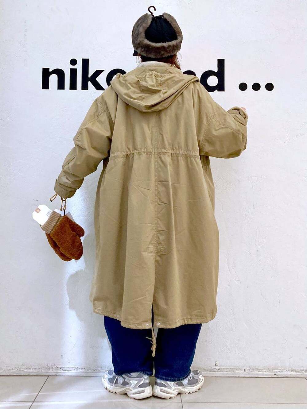 イエロー系のモッズコート、ブルー系のデニムパンツ、ホワイト系のTシャツ/カットソーを着用したレディースの秋コーディネートの4枚目の写真