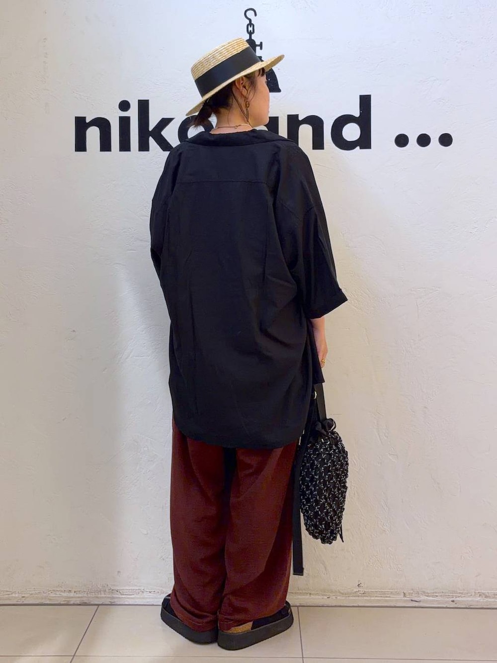 ブラック系のサンダル、ブラック系のトートバッグ、ホワイト系のTシャツ/カットソーを着用したレディースの夏コーディネートの5枚目の写真
