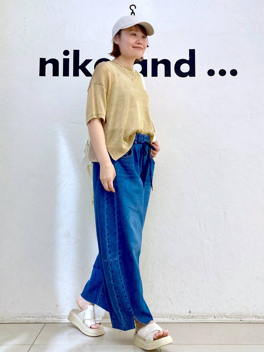 ベージュ系のサンダル、ブルー系のデニムパンツ、ベージュ系のタンクトップを着用したレディースの夏コーディネートの5枚目の写真