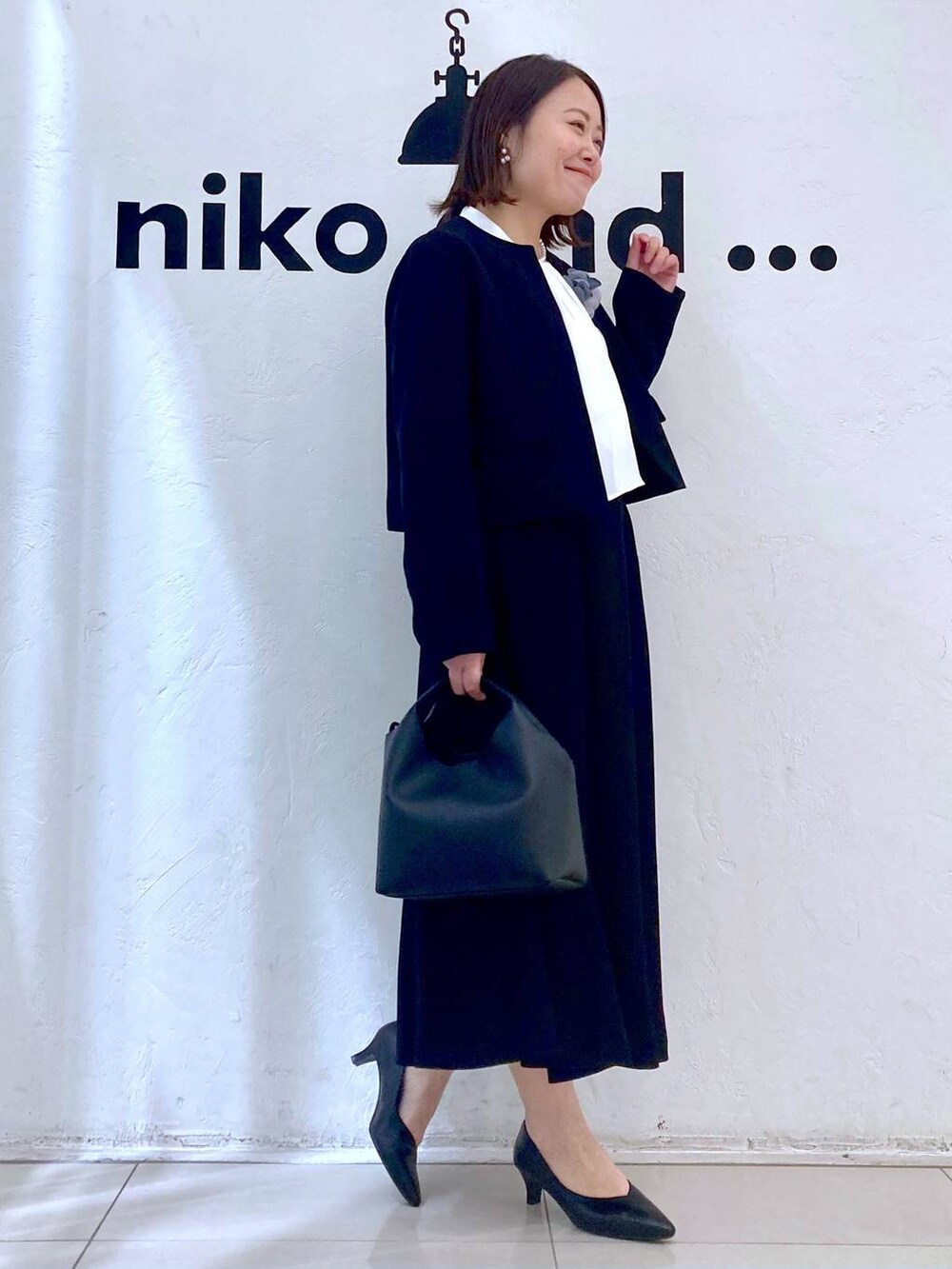 ホワイト系のシャツ/ブラウス、ブラック系のパンプス、ブラック系のノーカラージャケットを着用したレディースの冬コーディネートの4枚目の写真