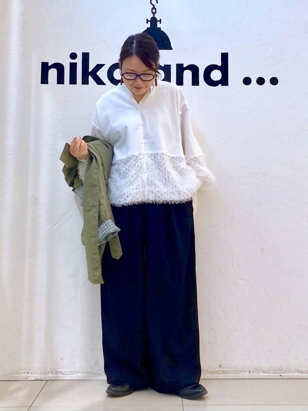 ブラック系のその他パンツ、グリーン系のトレンチコート、ホワイト系のシャツ/ブラウスを着用したレディースの冬コーディネートの2枚目の写真