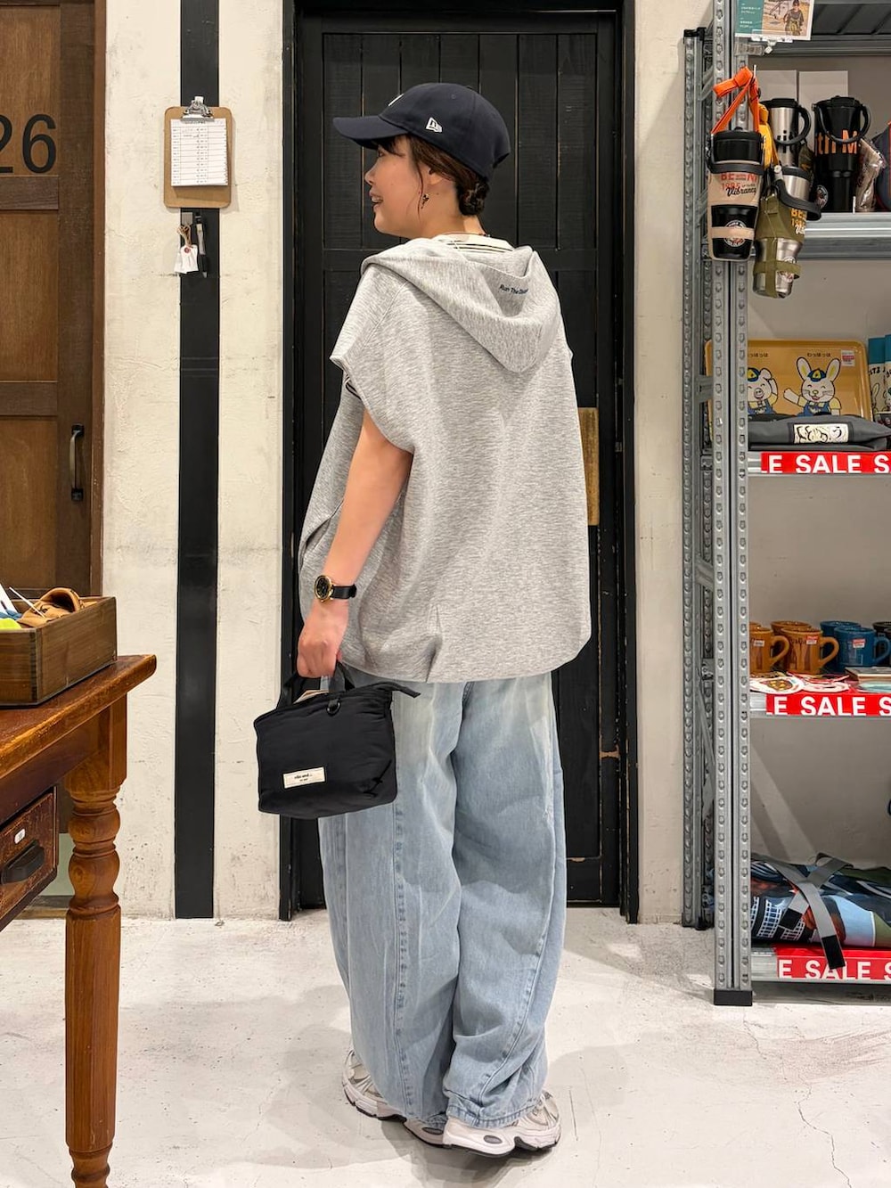 ブラック系のトートバッグ、その他のベスト、ベージュ系のTシャツ/カットソーを着用したレディースの夏コーディネートの4枚目の写真
