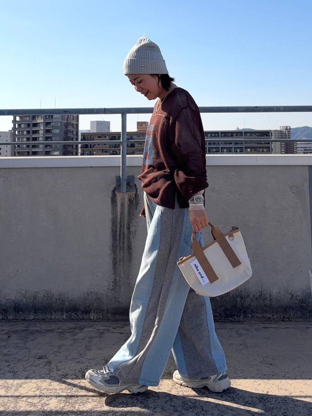 グレー系のデニムパンツ、ホワイト系のTシャツ/カットソー、その他のショルダーバッグを着用したレディースの春コーディネートの3枚目の写真