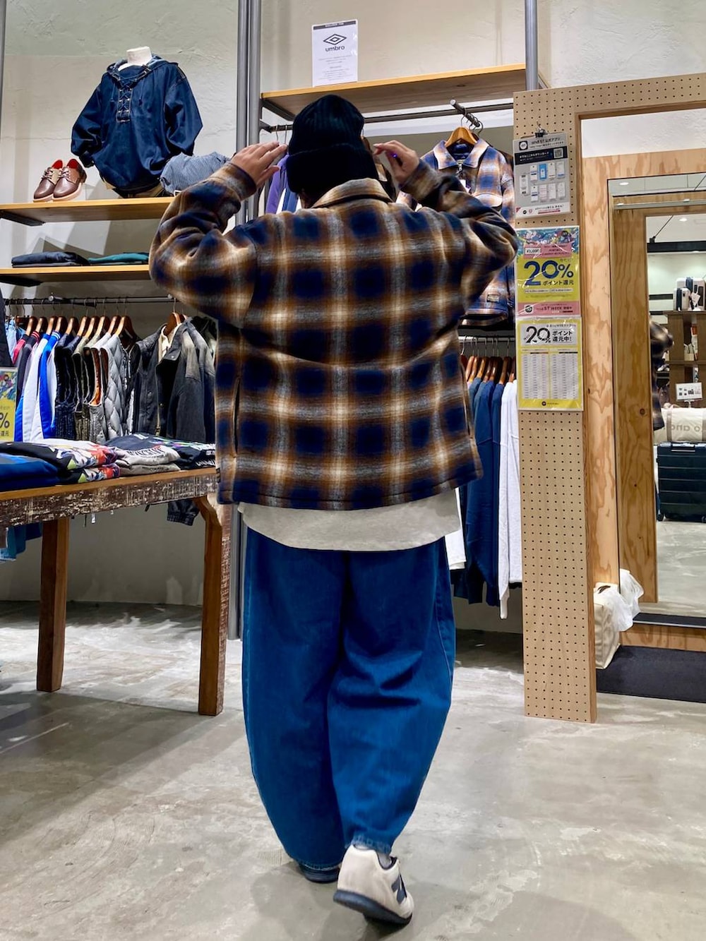 ブルー系のデニムパンツ、ブラウン系のブルゾン、ベージュ系のショルダーバッグを着用したレディースの秋コーディネートの6枚目の写真