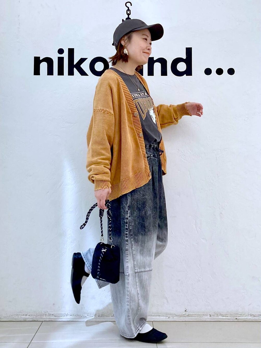 ブラック系のショルダーバッグ、グレー系のTシャツ/カットソー、ブラック系のデニムパンツを着用したレディースの秋コーディネートの5枚目の写真