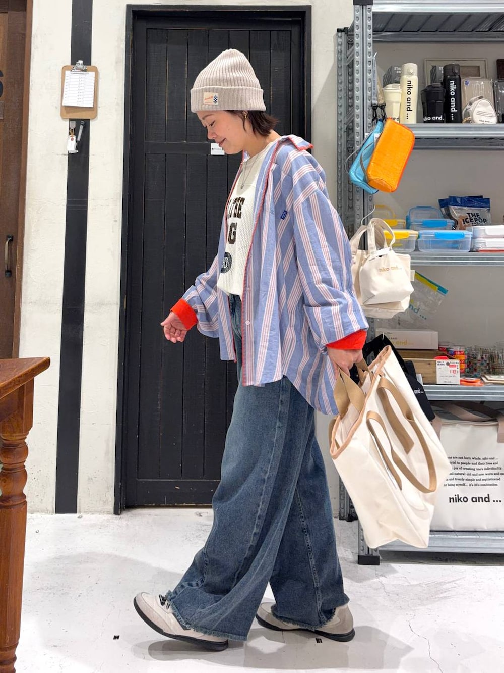 ブルー系のデニムパンツ、ホワイト系のタンクトップ、その他のトートバッグを着用したレディースの春コーディネートの3枚目の写真