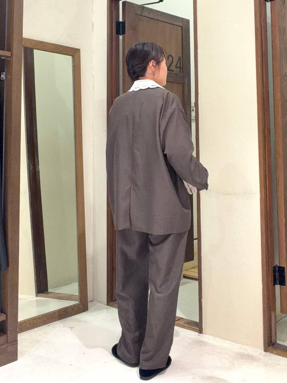 グレー系のショルダーバッグ、ブラック系のパンプス、ブラウン系のテーラードジャケットを着用したレディースの冬コーディネートの5枚目の写真