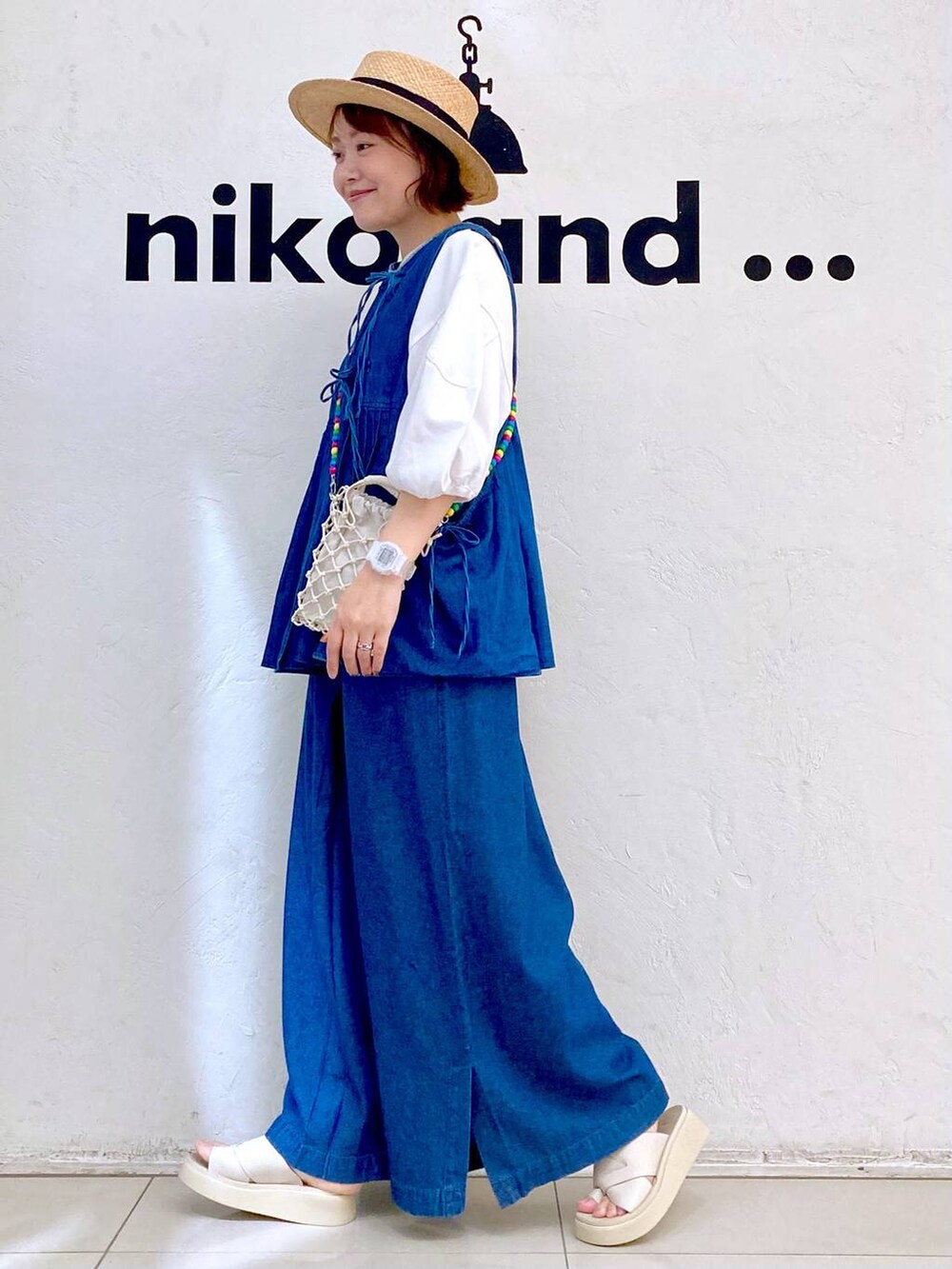 ベージュ系のショルダーバッグ、ベージュ系のサンダル、ホワイト系のTシャツ/カットソーを着用したレディースの夏コーディネートの5枚目の写真