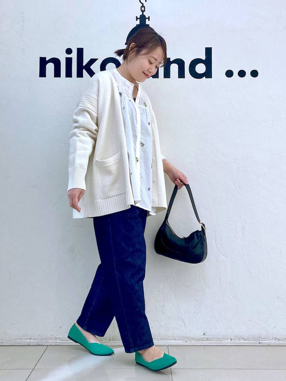 ブラック系のショルダーバッグ、ホワイト系のシャツ/ブラウス、グリーン系のパンプスを着用したレディースの春コーディネートの3枚目の写真